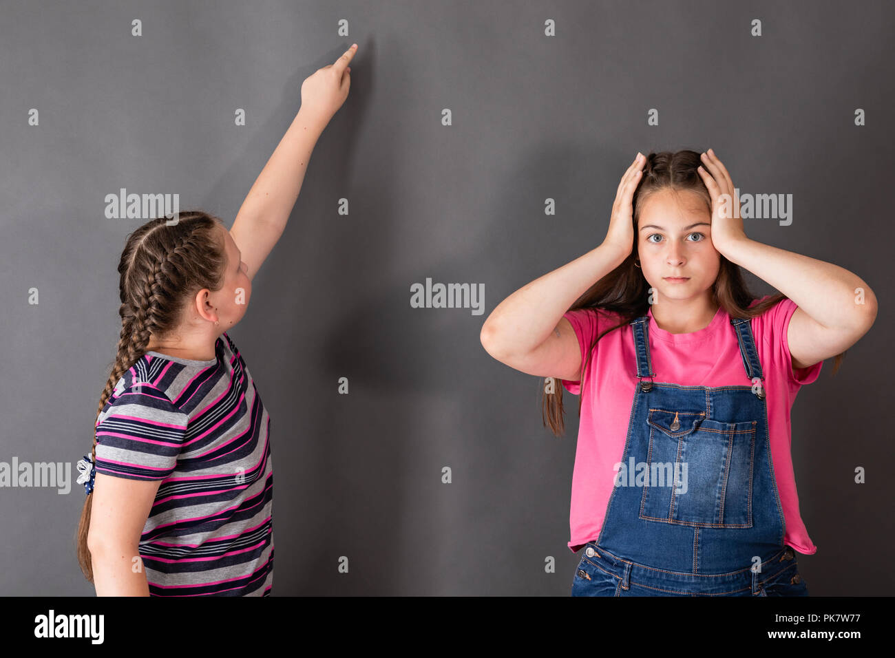 Ein Mädchen ist überrascht, wie leicht und schön die anderen die Aufgabe löst. Freien Speicherplatz für Ihre Themen Stockfoto