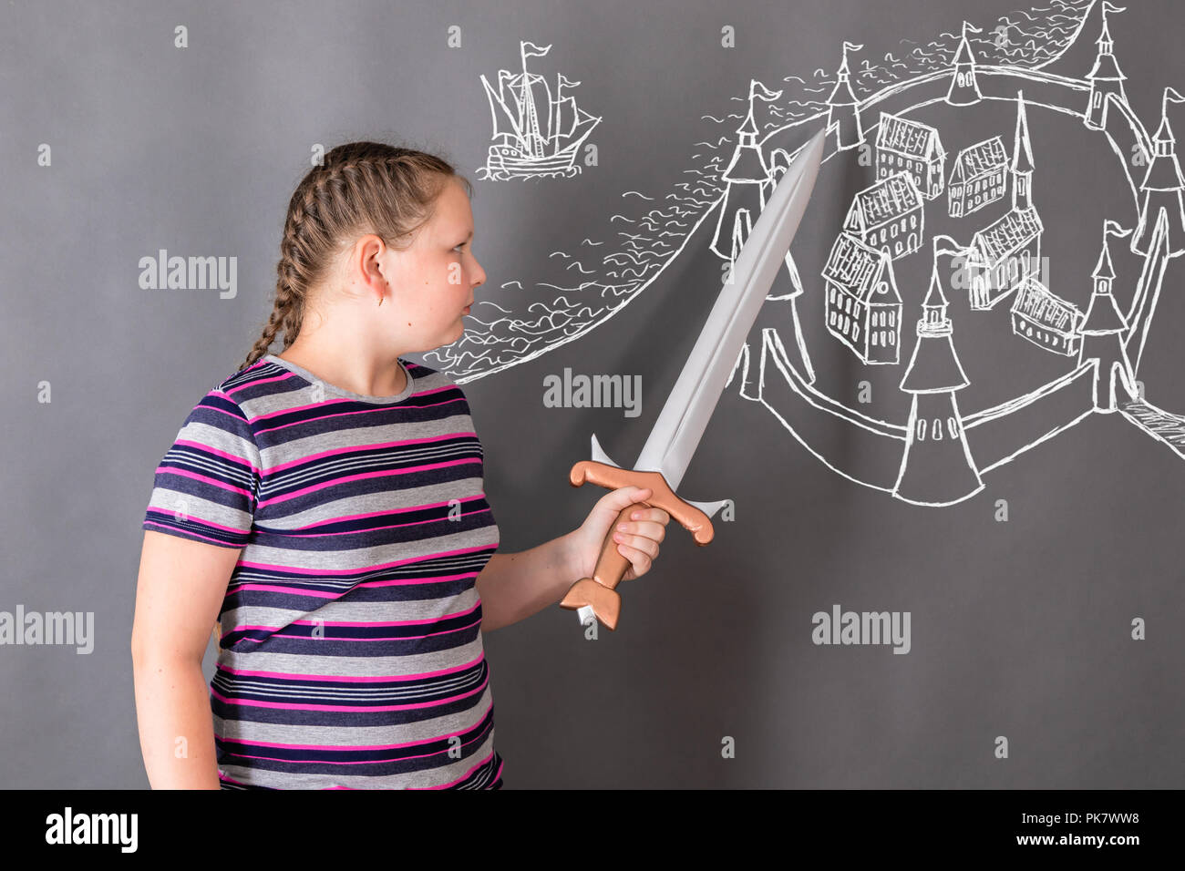 Das Mädchen ist die Entwicklung eines Plans für die mittelalterliche Festung, zeigen sie mit dem Schwert in die Schwachstellen in der Verteidigung auf die gezeichneten Plan Stockfoto