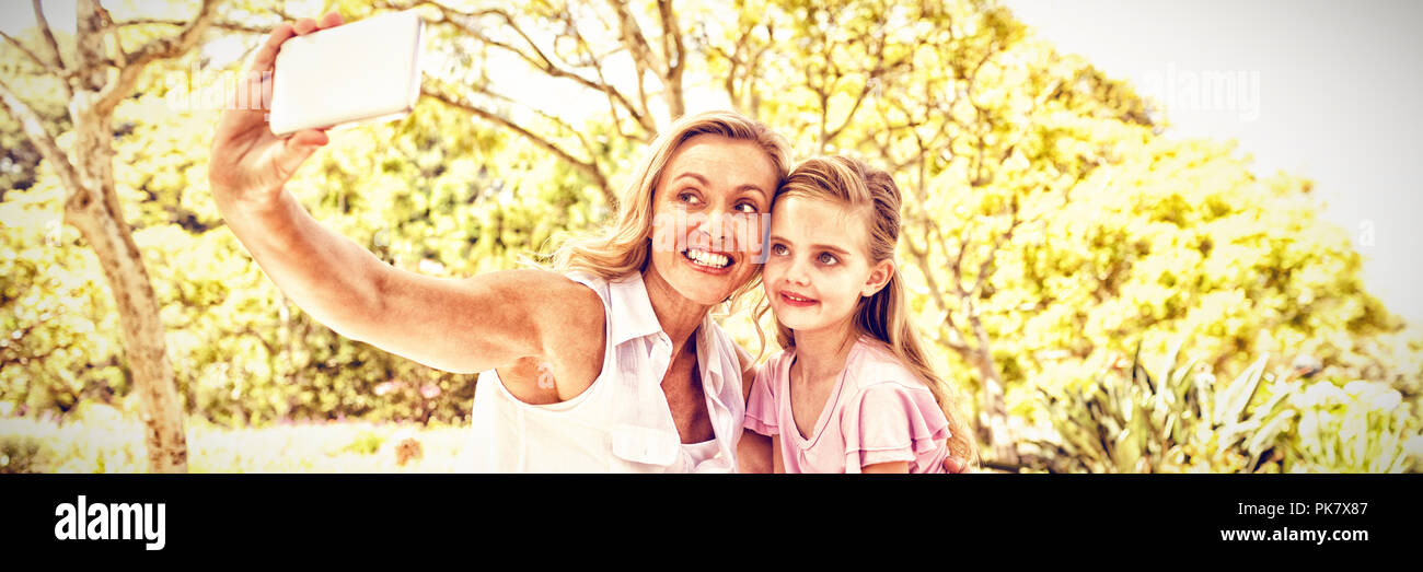 Mutter und Tochter unter selfie auf Handy im Park Stockfoto