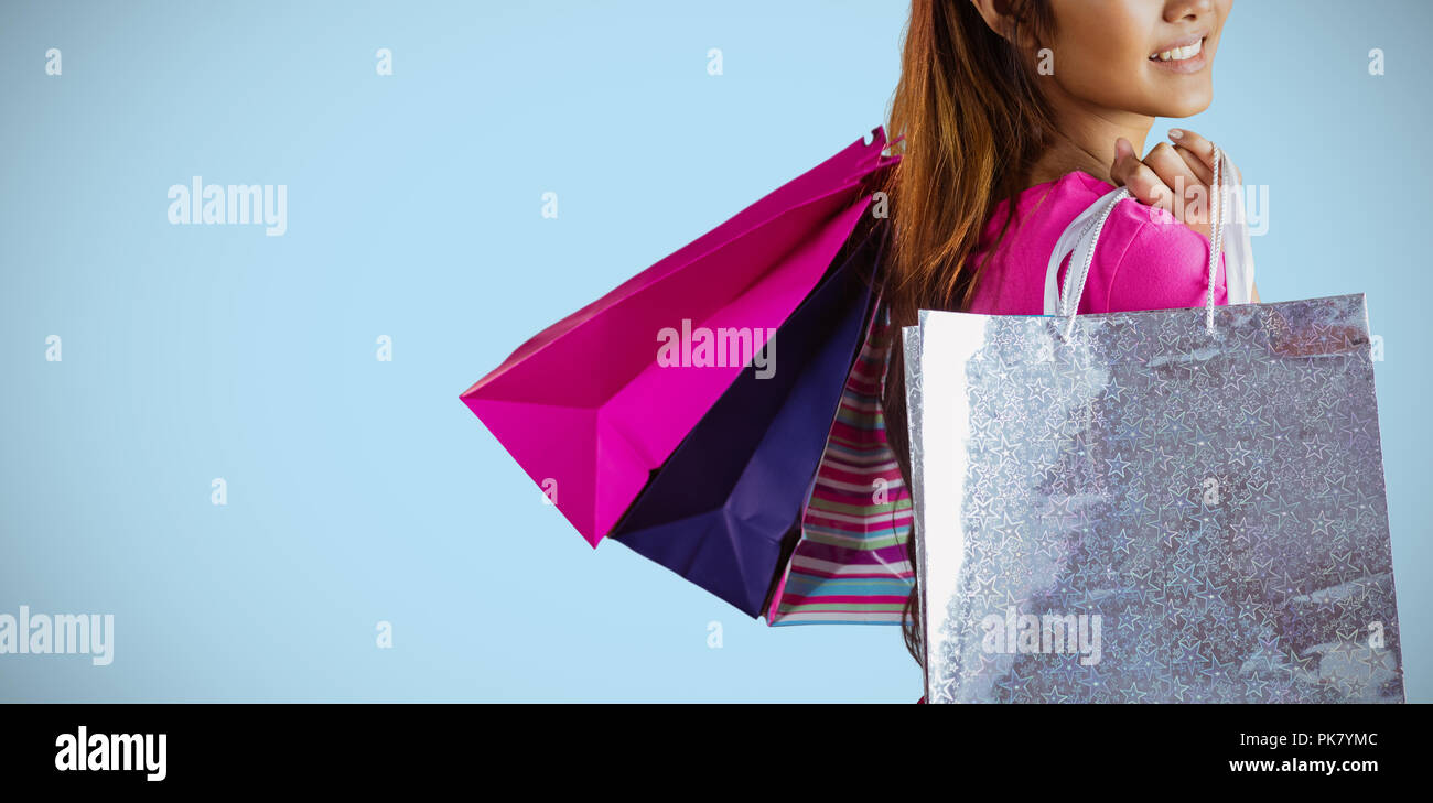 Zusammengesetztes Bild des lächelnden Asiatin mit Einkaufstüten Stockfoto