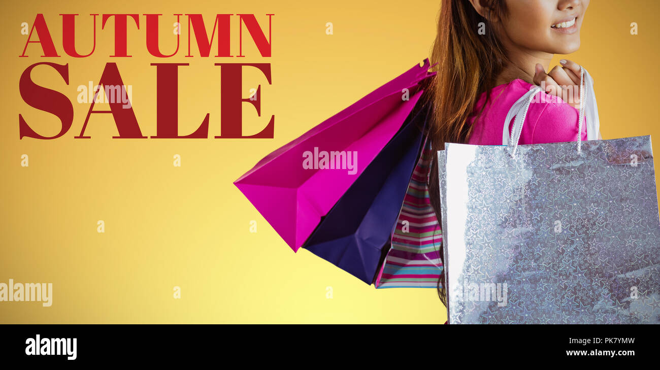 Zusammengesetztes Bild des lächelnden Asiatin mit Einkaufstüten Stockfoto