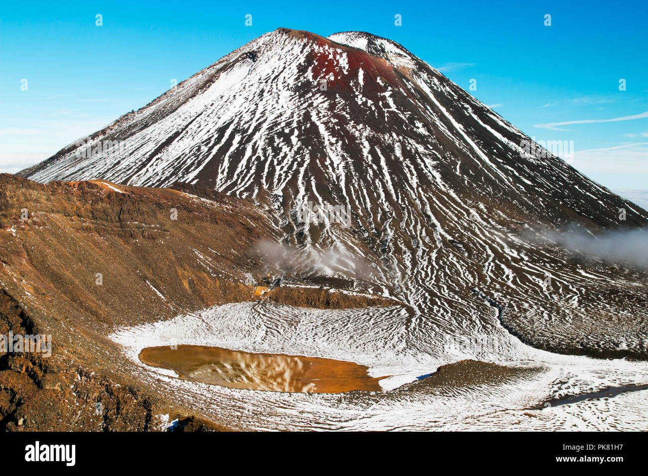 Meisterwerke der Natur Wunder, riesige aktiven Vulkan mit roter Spitze oben Sulfid Wasser See mit Spiegel Reflexion auf die schneebedeckten Berge, Neuseeland Stockfoto