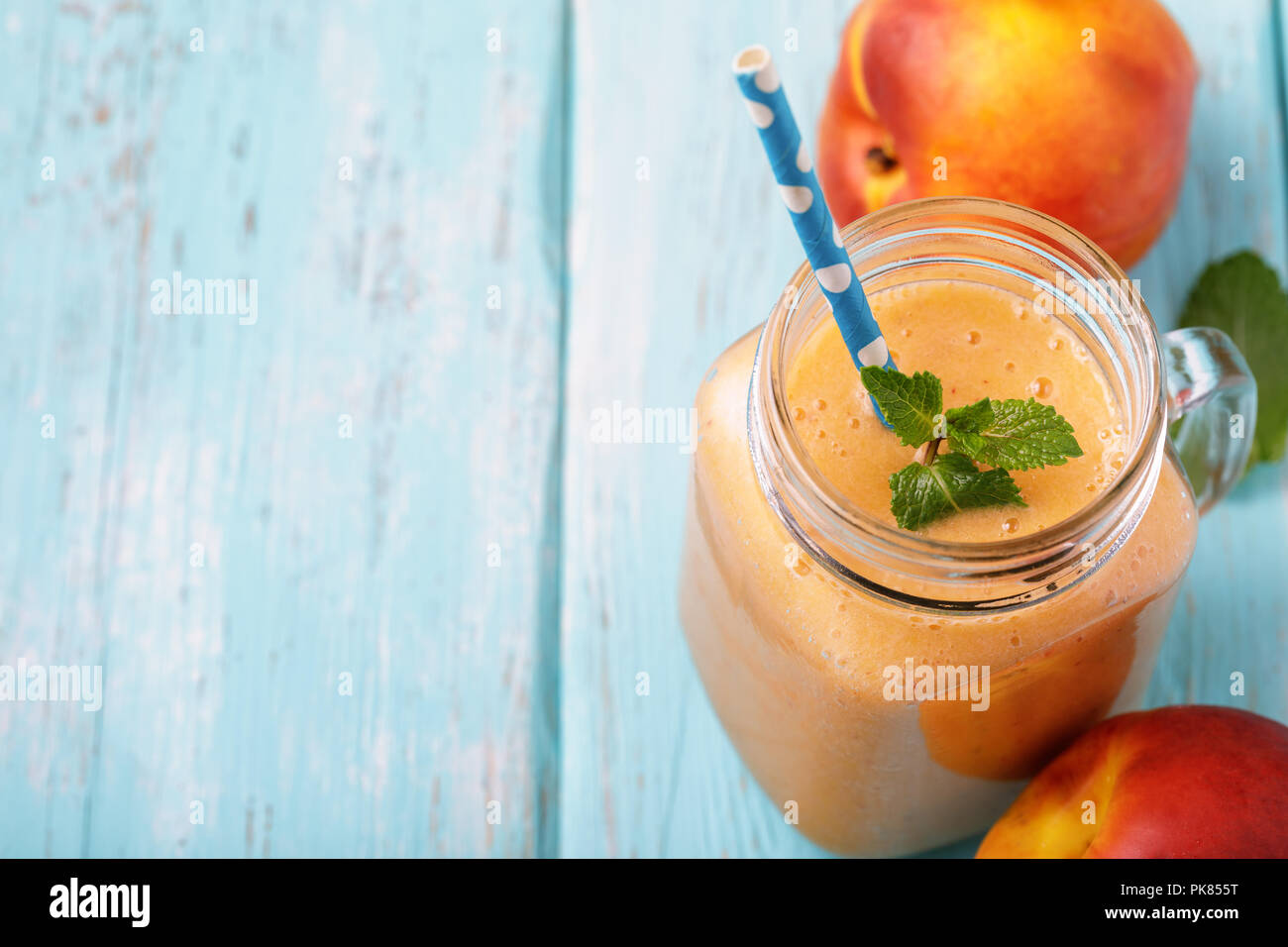Smoothies von reife Pfirsiche im Glas mit Minze und Früchte auf einer hölzernen Tisch vorbereitet. Essen mit Platz für Text Stockfoto