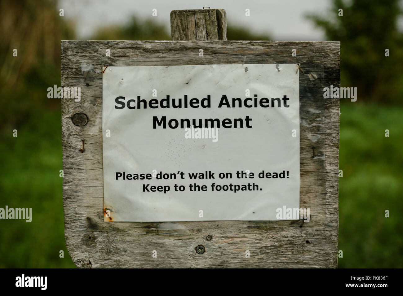 Ein Zeichen Warnung, sich nicht auf die Toten, die einem alten Monument zu Fuß Stockfoto