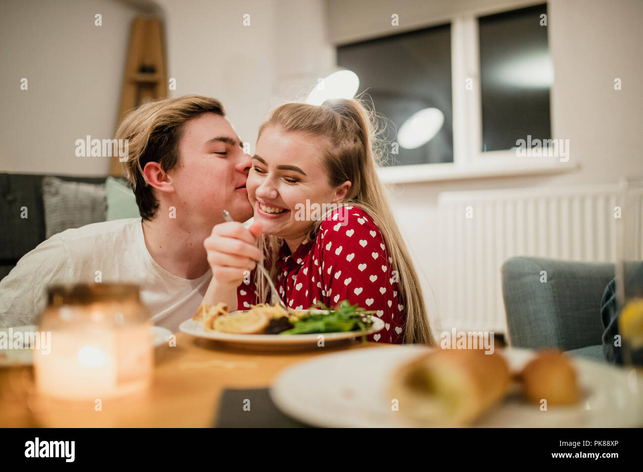 Glückliches junges Paar werden romantische während das Abendessen zu genießen. Stockfoto