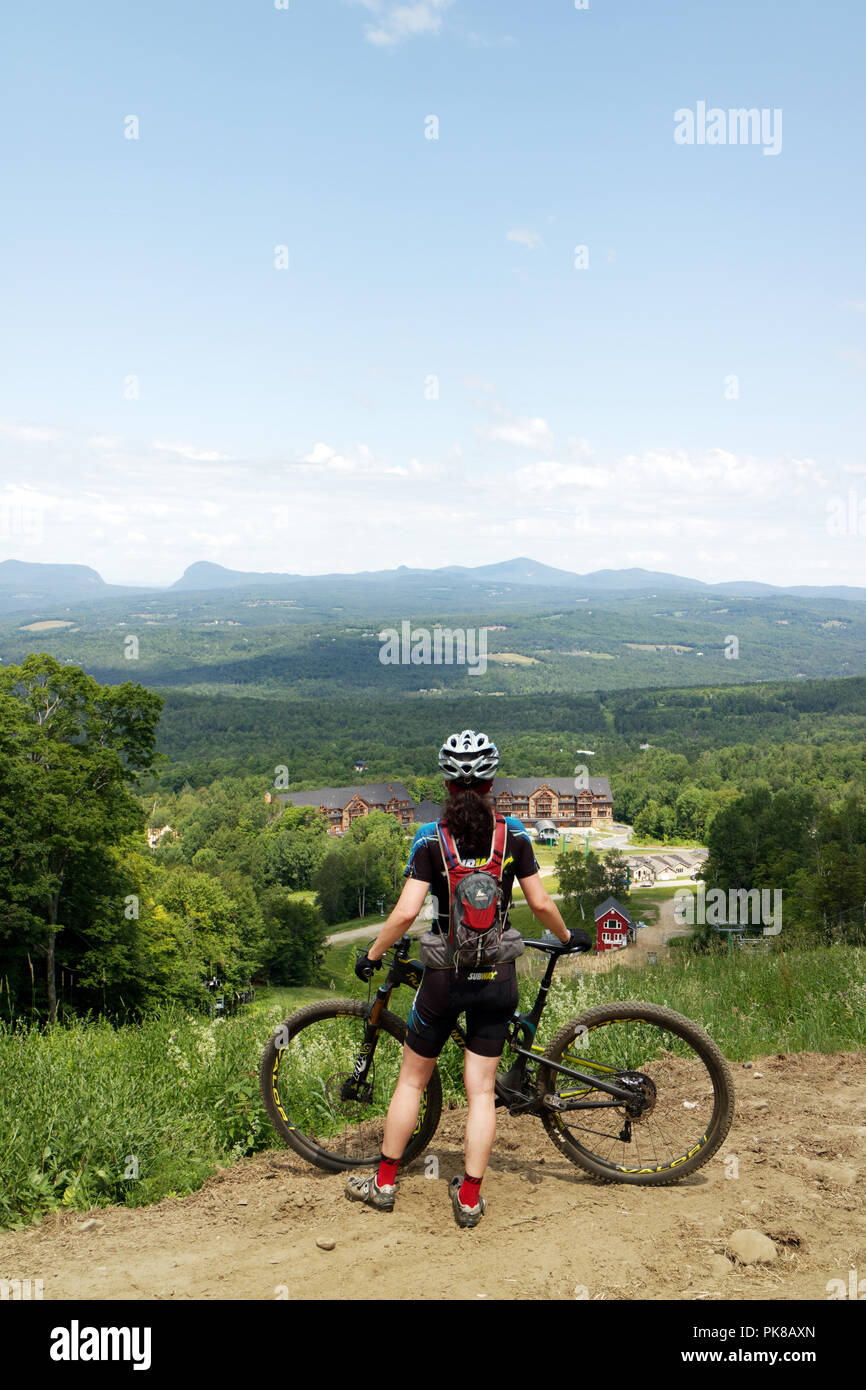 Eine Dame Mountainbiker (in ihrem 40s) hält den Blick auf das Königreich Trails mountain bike Park im Osten Burke, Vermont, USA zu bewundern. Stockfoto