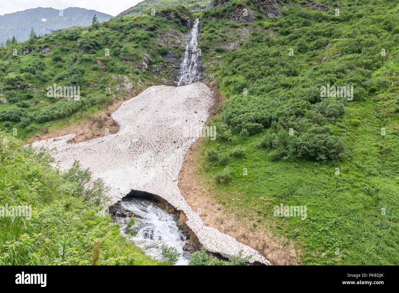 Bleibt der Eis- und Schneedecke über einem Bergbach im Sommer, Österreich Stockfoto