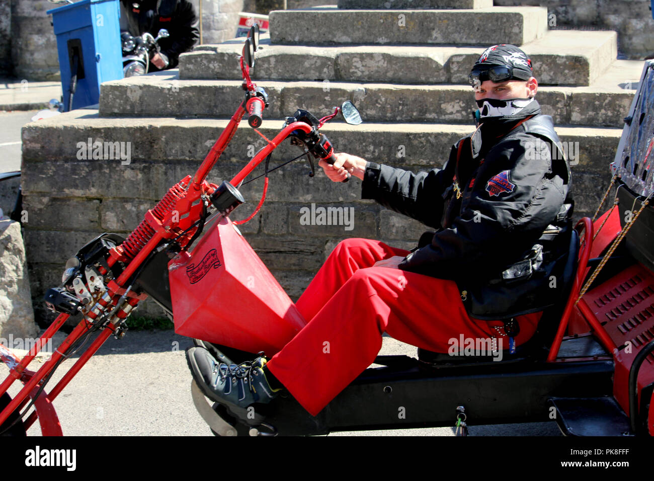 Corfe, England - 03. Juni 2018: Mittlere suchen Biker auf einem Chopper trike Motorrad, tragen schwarz und rot, mit bandanas über seinem Kopf und Gesicht Stockfoto