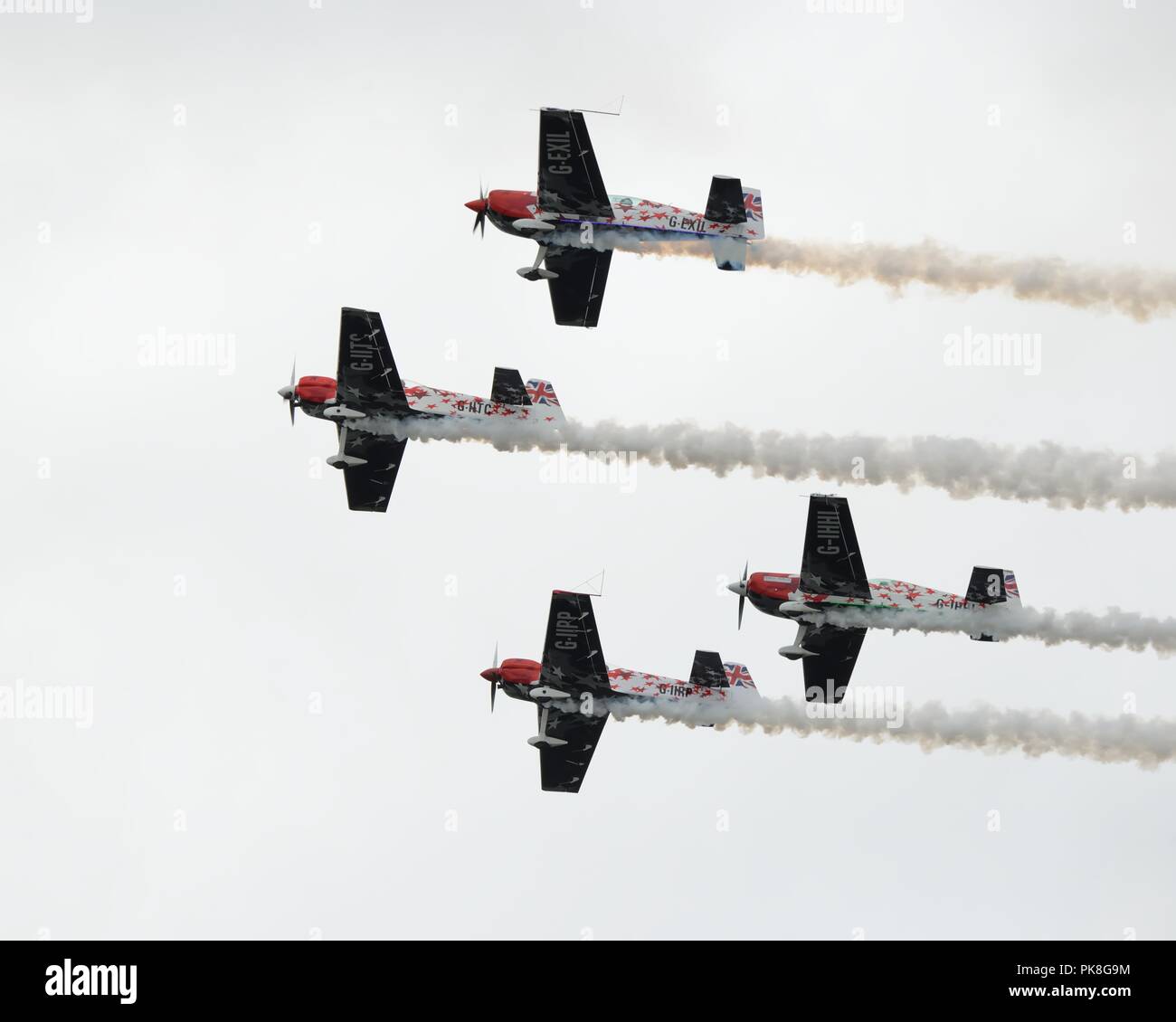 Präzisionsgruppen fliegen von Global Stars Kunstflugteam in ihrem Extra EA.300S Flugzeug auf der Scottish International Air Show in Schottland, Großbritannien Stockfoto