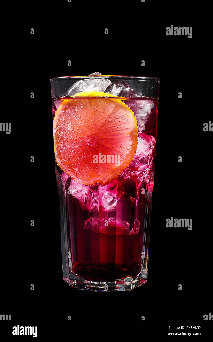 Ein lila, pink transparent Cocktail, erfrischende in ein hohes Glas mit Eiswürfeln und Zitrone in Scheiben schneiden. Seitenansicht isolierten schwarzen Hintergrund. Getränk für Männer Stockfoto