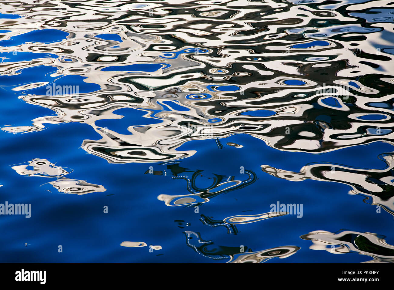 Abstrakte Reflexion einer Yacht im Hafen von Marbella an der Küste Spaniens Stockfoto