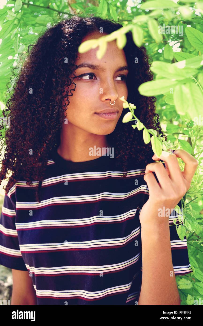 Junge Frau von grünen Blättern umgeben Stockfoto