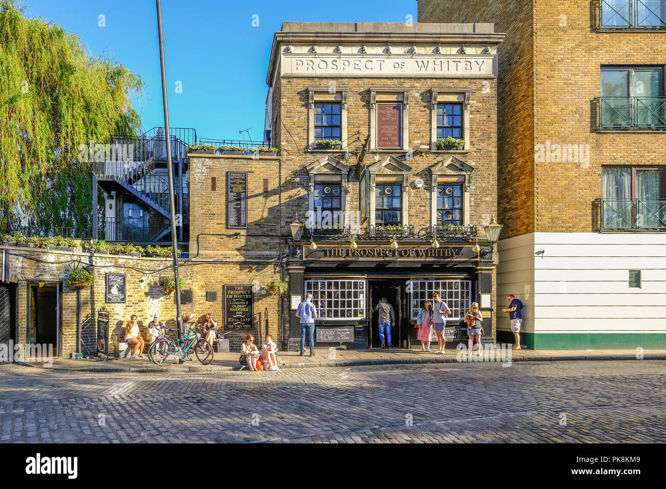 Wapping, London, Großbritannien - 7. Mai 2018: Horizontale Schuß von der Aussicht von Whitby Pub in Wapping mit Menschen in der Sonne draußen. Nachmittag geschossen Stockfoto