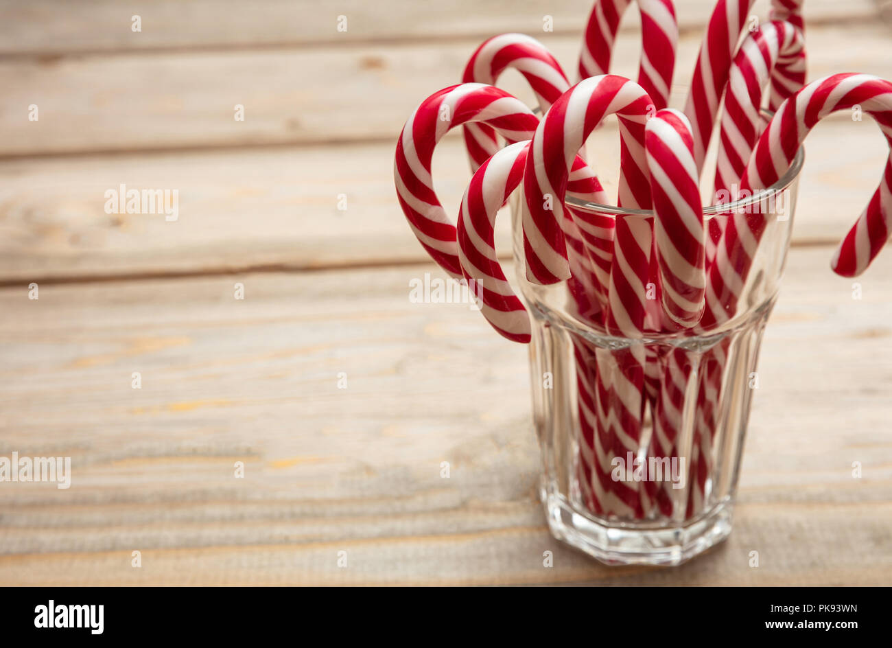 Der Weihnachtszeit. Zuckerstangen in einem Glas, Holz- Hintergrund, kopieren Raum Stockfoto