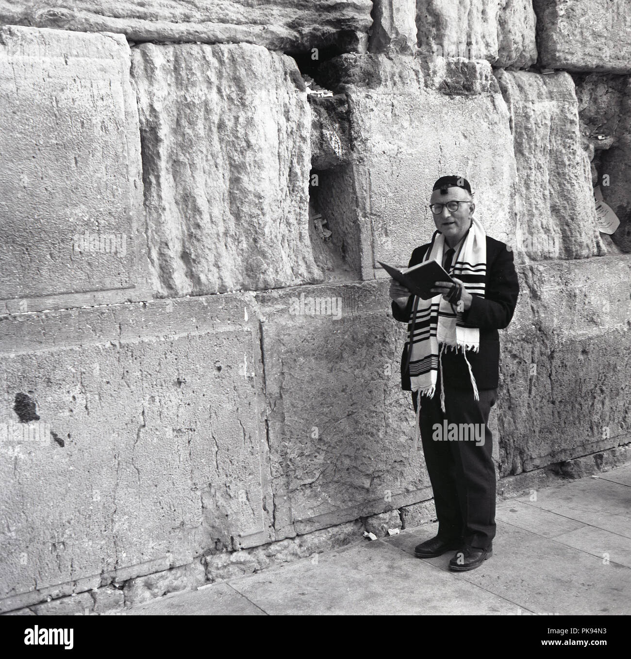 1950, historische, ein jüdischer Mann mit einem Gebetbuch in der westlichen Wand in der Altstadt von Jerusalem. Von 1948 diese heilige religiöse Stätte für das Jüdische Volk wurde unter jordanischer Herrschaft und dies dauerte bis 1967. Stockfoto