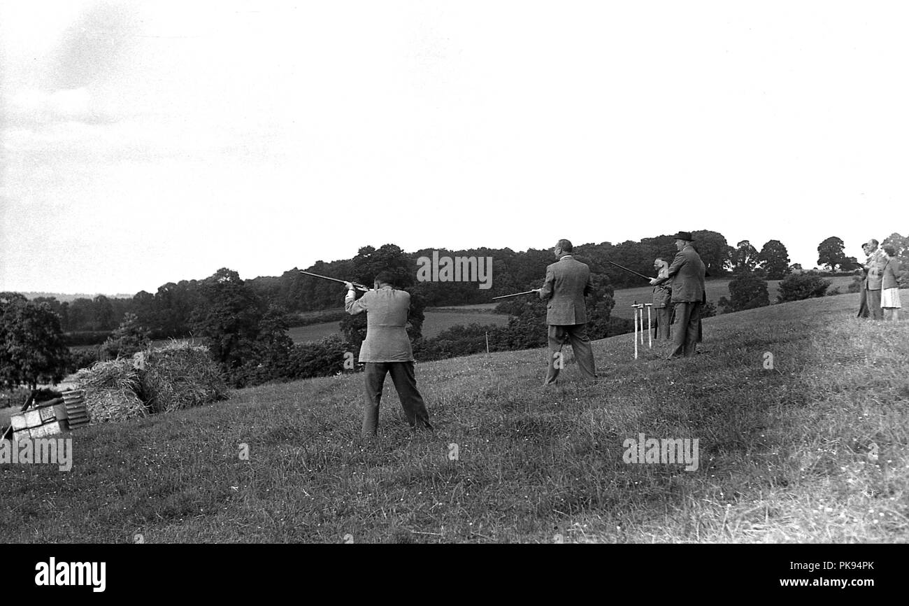 1930er Jahre, historischen, ländlichen Land Verfolgungsjagden, Herren in geeignete Kleidung, die an einem Schießen auf einem Hügel, traditionelle britische Landschaft fieldsport. Stockfoto