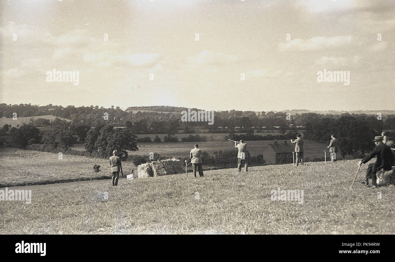 1930er Jahre, historischen, ländlichen Land Verfolgungsjagden, Herren in geeignete Kleidung, die an einem Schießen auf einem Hügel, traditionelle britische Landschaft fieldsport. Stockfoto