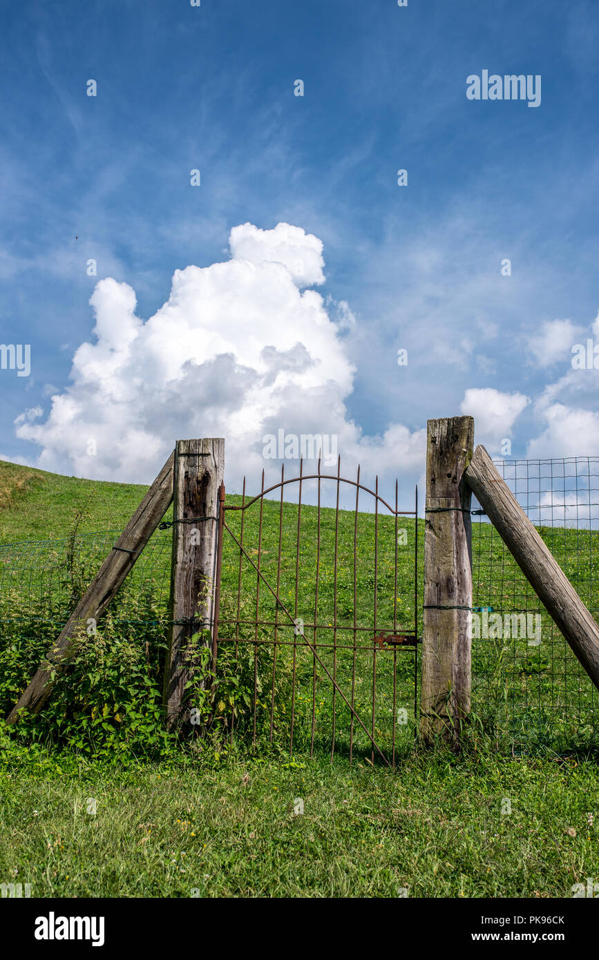 Iron Gate rustikaler Zaun auf einer grünen Wiese, Pforte des Himmels auf einem Hügel Stockfoto