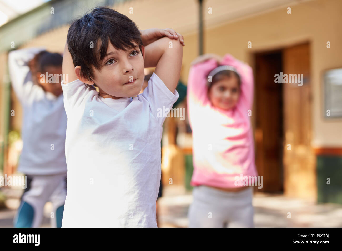 Kinder tun stretching Turnen in der Grundschule Sportunterricht Stockfoto