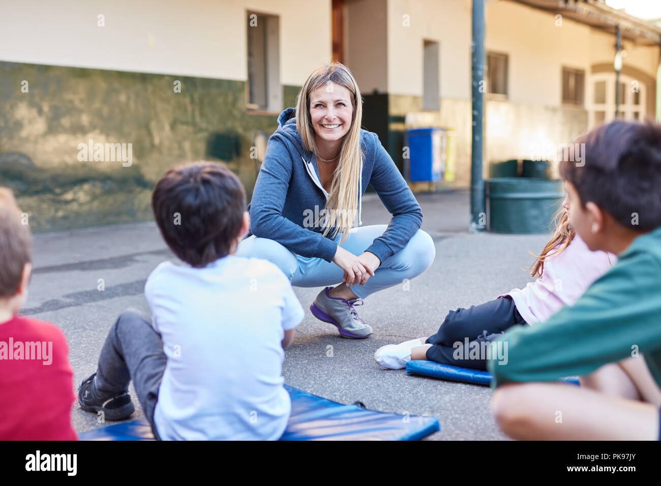 Frau als Lehrer und Schüler im Sportunterricht auf dem Schulhof Stockfoto