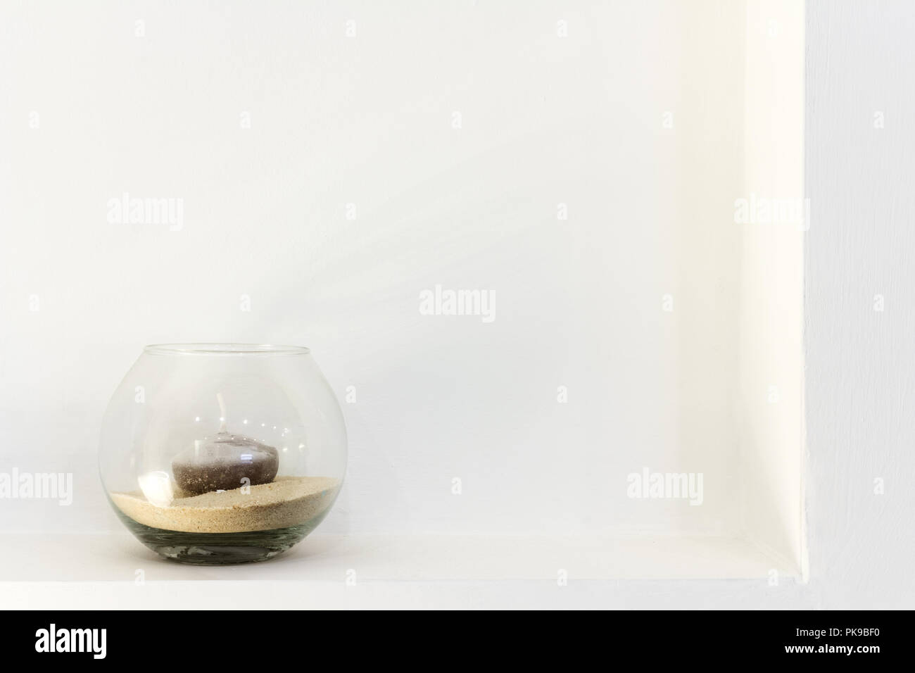 Glas Vase mit einer Kerze, weiße Wand Stockfoto