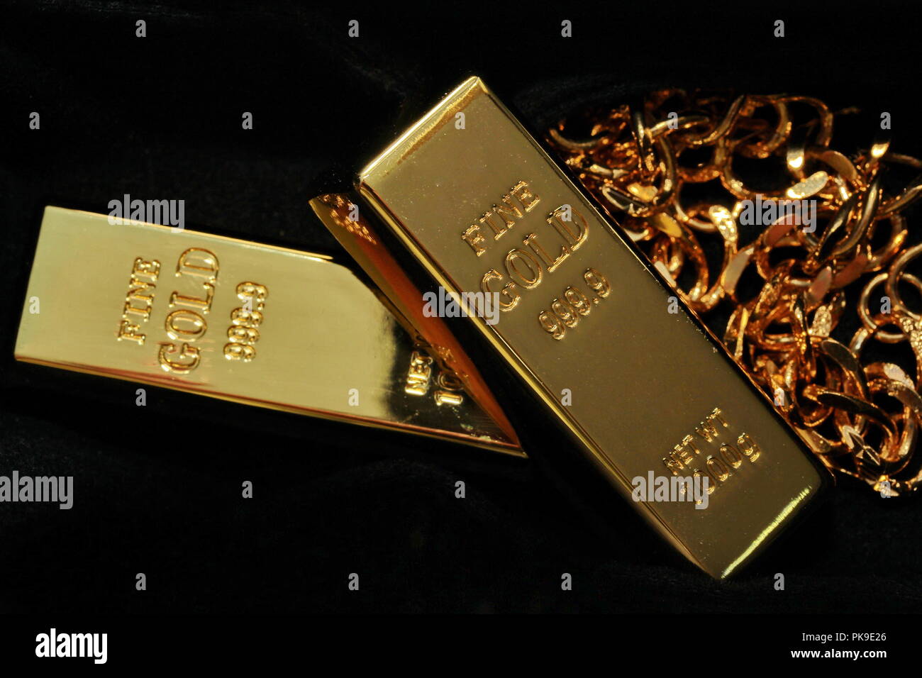 Goldbarren mit einem Gewicht von 1 kg, 2 sticks gestapelt und goldene  Halskette in Finsternis, selektive konzentrieren Stockfotografie - Alamy