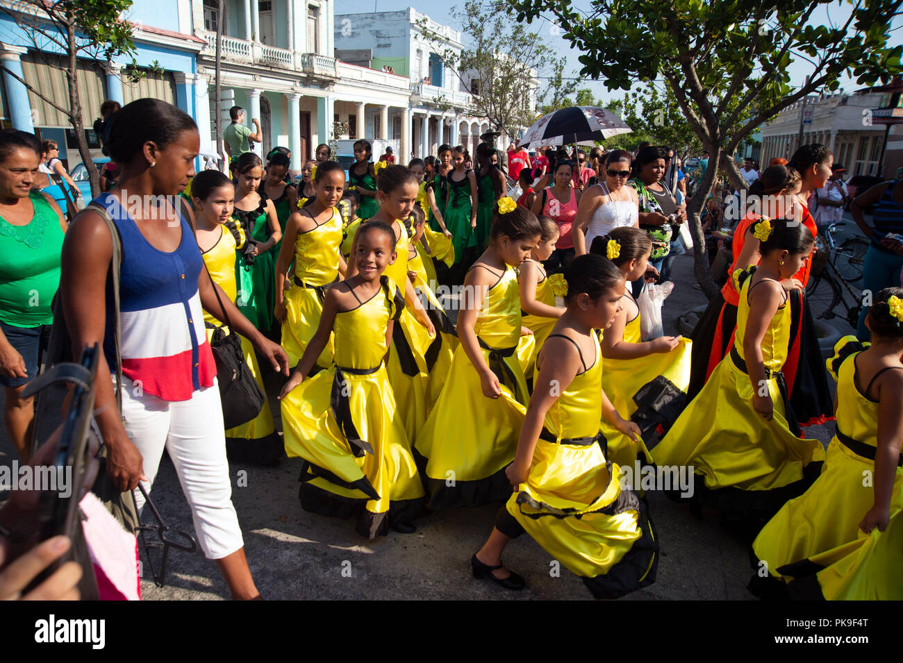 Kubanischen Mutter Hand Ihres Kindes, wie sie in einem bunten Street Parade in Cienfuegos Kuba berücksichtigen Stockfoto