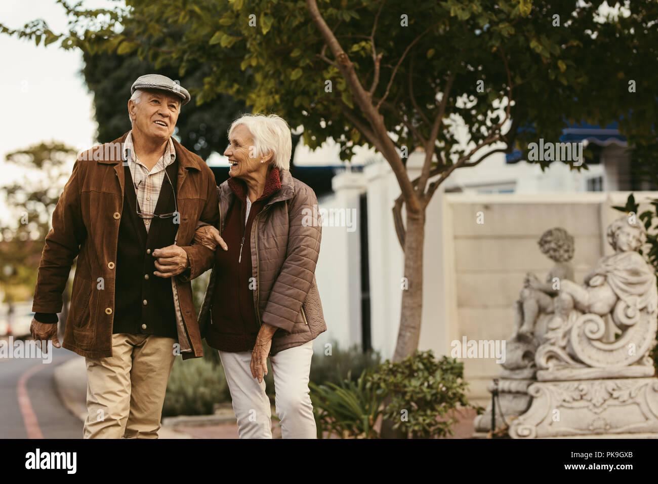 Portrait von Happy pensionierter Mann und Frau tragen warme Kleidung zusammen gehen im Freien auf Straße der Stadt. Senior Paar genießen einen Spaziergang auf einer Winte Stockfoto