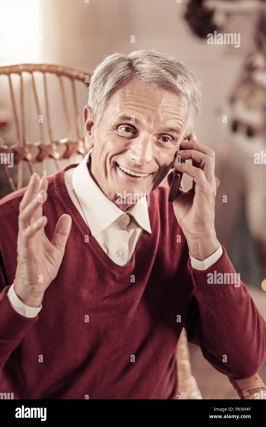 Lustiger Mann lächelnd und in Konversation beeindruckt. Stockfoto