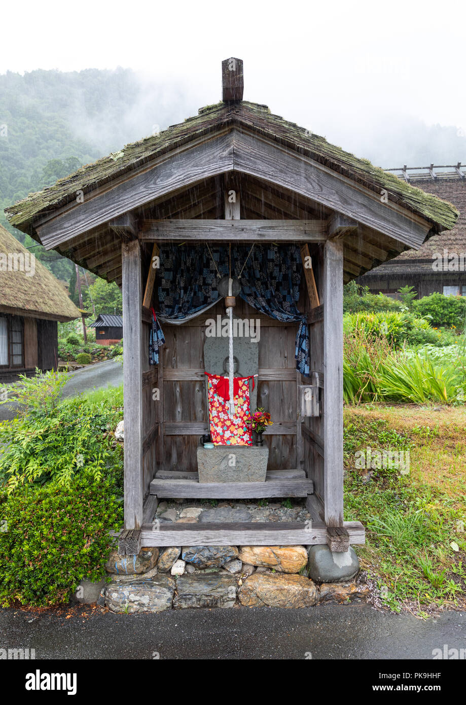 Japanische steinerne Statue in einem kleinen Shinto Schrein, Präfektur Kyoto, Miyama, Japan Stockfoto