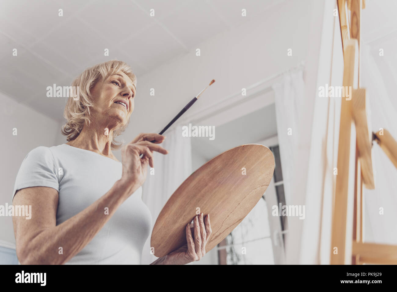Pensionierte Frau noch Malerei Leben inspiriert Stockfoto