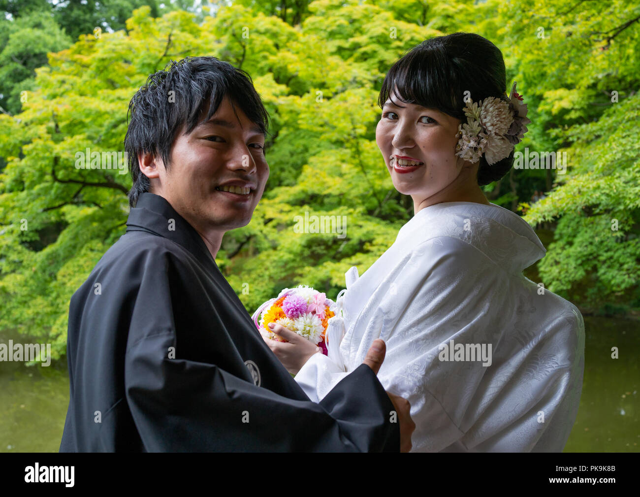 Japanisches Paar in traditioneller Kleidung im botanischen Garten, Region Kansai, Kyoto, Japan Stockfoto