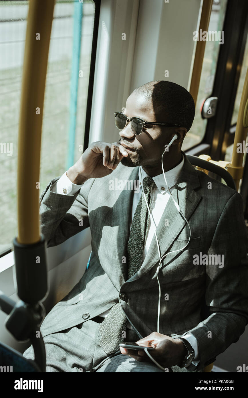 Afrikanische amerikanische Geschäftsmann tragen Anzug das Hören von Musik während der Zug Stockfoto