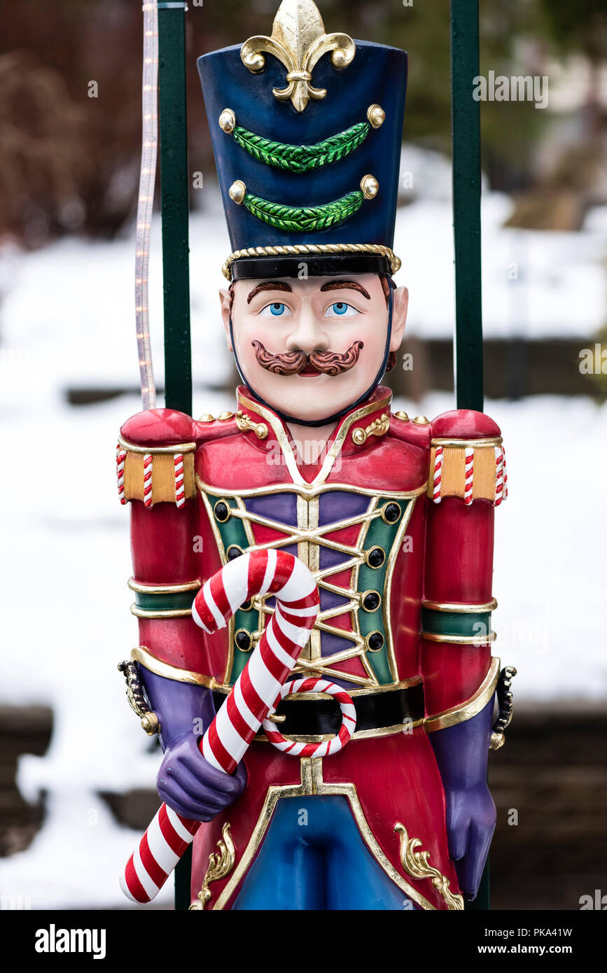 Ein Spielzeugsoldat Weihnachtsdekoration in einer roten Uniform hält eine Zuckerstange. Stockfoto