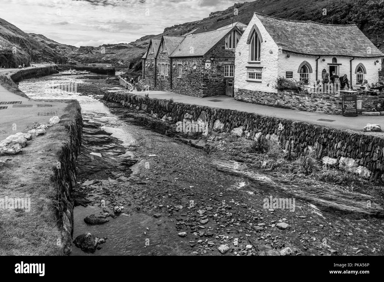 Touristen genießen eine kurze Atempause von der anhaltenden Stürme, die in den malerischen kleinen Hafen von Boscastle an der Nordküste von Cornwall. Stockfoto