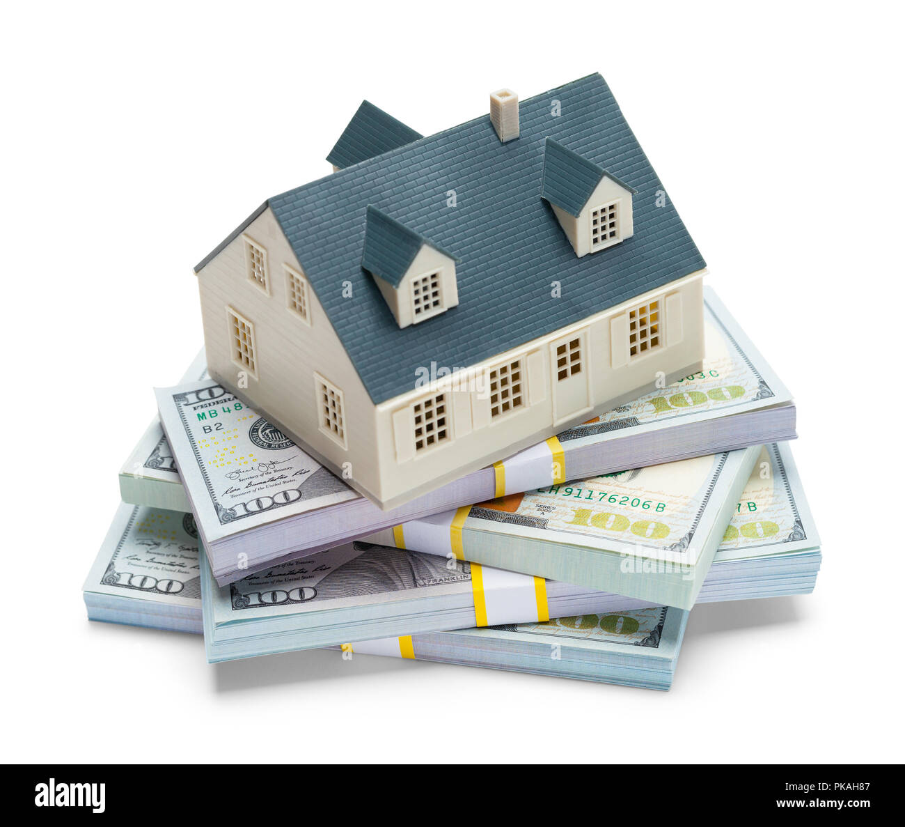 Haufen Geld mit Haus auf der Oberseite isoliert auf Weiss. Stockfoto