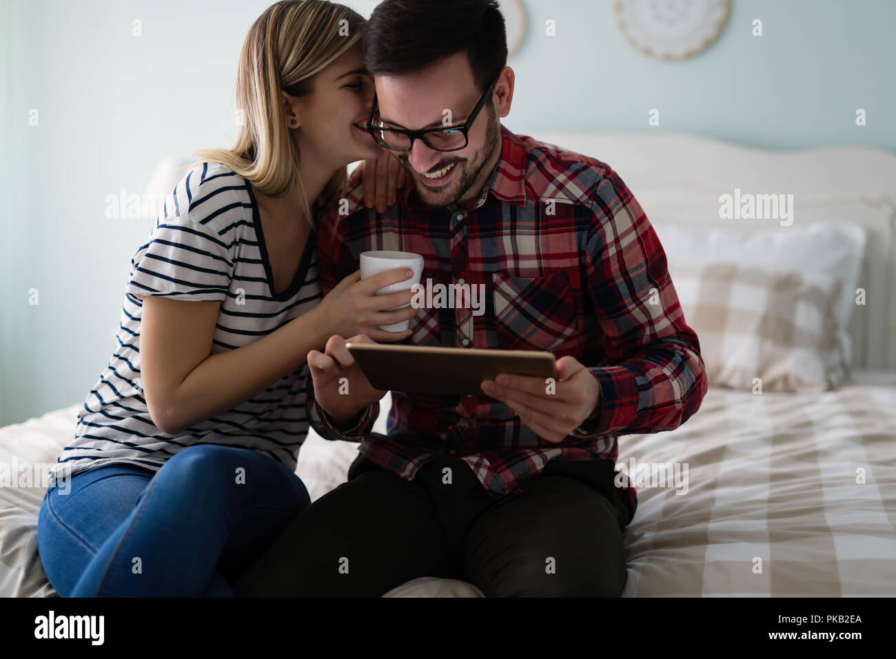 Junges attraktives Paar mit Tablet-PC im Schlafzimmer Stockfoto