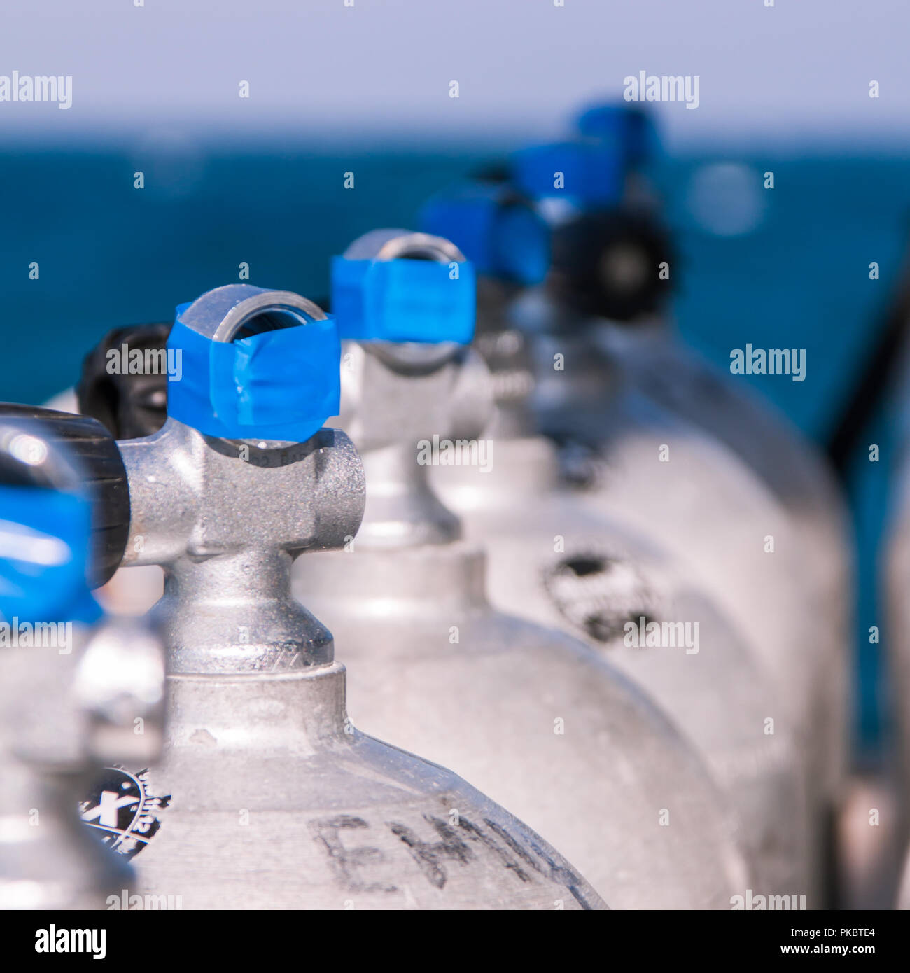 Tauchen Tanks mit blauem Klebeband und Meer im Hintergrund Stockfoto