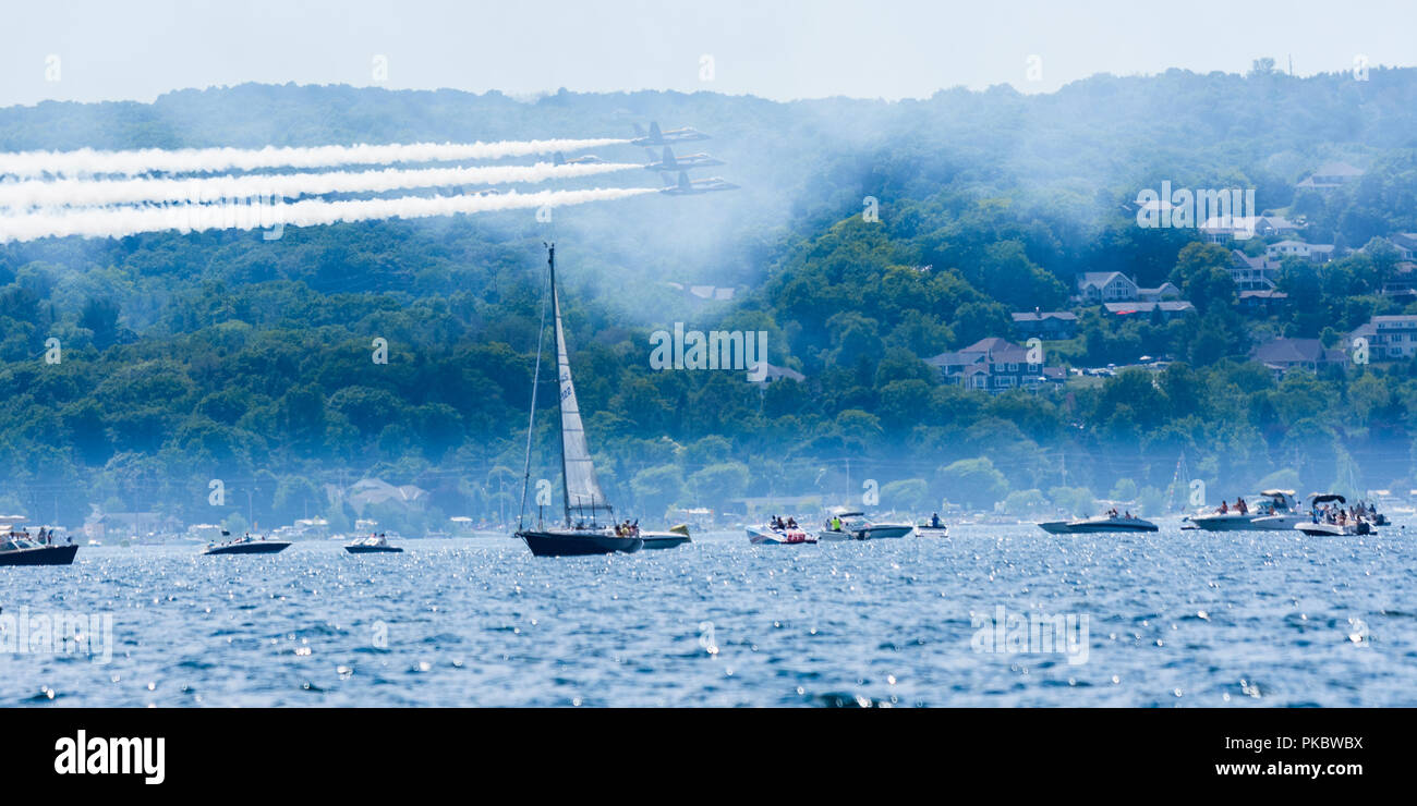 Drei F/A-18 Hornet-Jets der United States Navy Flight Demonstration Squadron, die Blue Angels fliegen tief über Bootsfahrer, die in Traverse City, MI, zusehen. Stockfoto