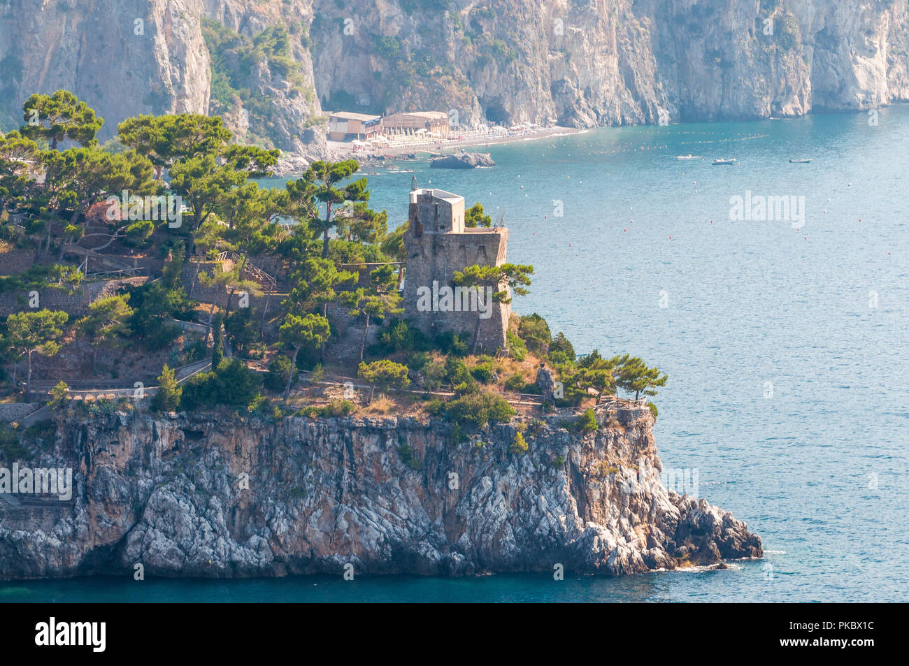 Eine alte Backstein Turm auf einer felsigen Landzunge mit Bäumen auf dem Mittelmeer, Salerno, Italien Stockfoto
