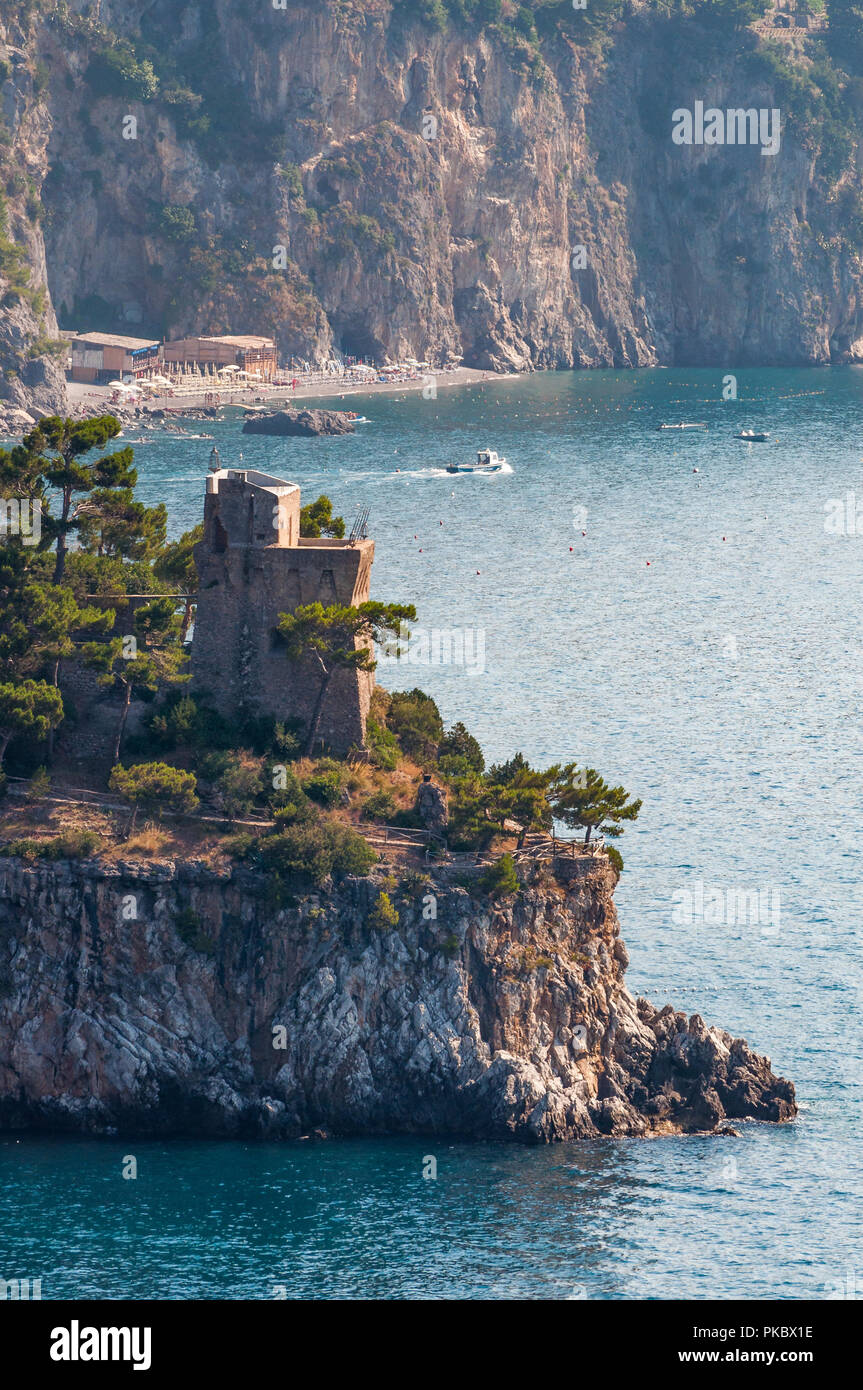 Eine alte Backstein Turm auf einer felsigen Landzunge mit Bäumen auf dem Mittelmeer, Salerno, Italien Stockfoto