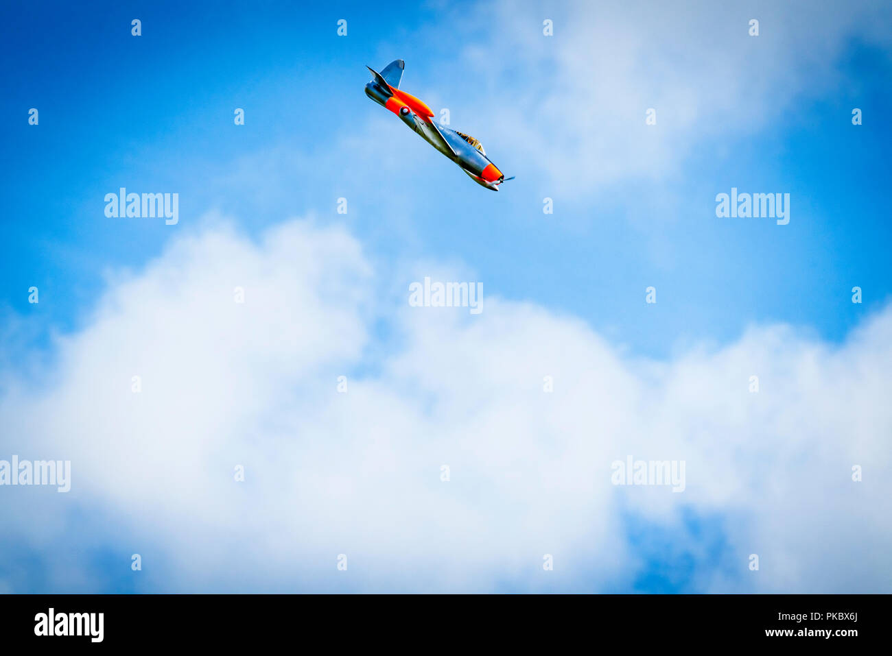 Ebene tauchen auf einem blauen Himmel mit weißen Wolken Stockfoto