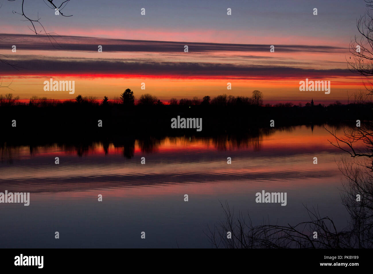 Sonnenuntergang im Sommer auf dem Fluss Sava im Naturpark Lonjsko Polje, Kroatien, Kirche Glockenturm Silhouette am Horizont Stockfoto