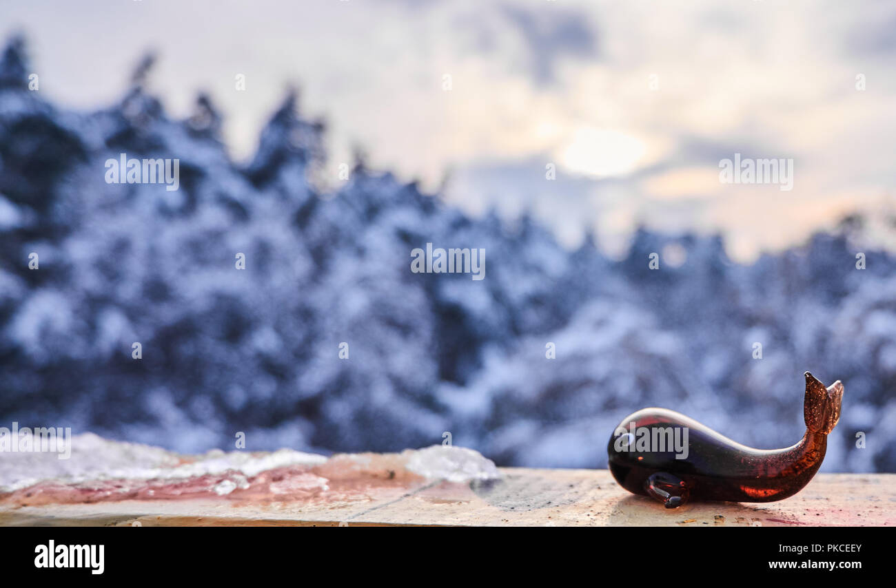 Winter Hintergrund. Glas wal Spielzeug vor park Bäume mit Schnee bedeckt Stockfoto