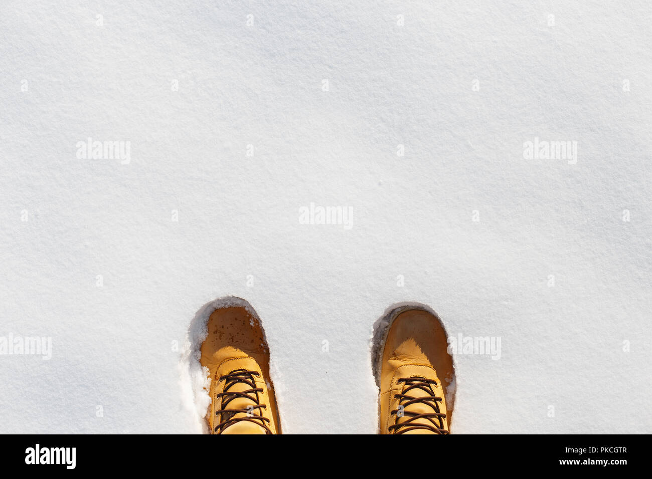 Menschlichen Beinen mit Leder gelb Stiefel im Schnee. Ansicht von oben Stockfoto