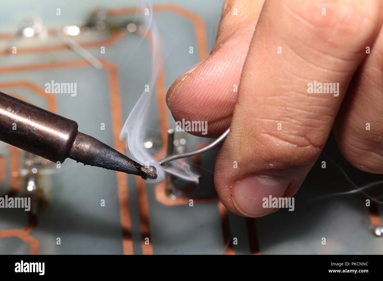 Elektronische Schaltungen Verfahren, Schweißkopf mit Tin-Draht zu Schaltungen auf Leiterplatten Schweißen mit Lötkolben. Selektive konzentrieren. Stockfoto