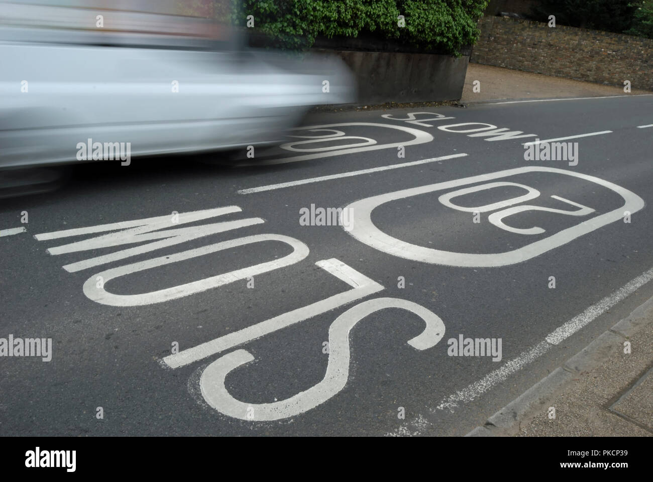 Fahrzeug in Bewegung verwischt, die Fahrbahnmarkierungen beschreibt ein 20 mph Höchstgeschwindigkeit in Ham, Surrey, England Stockfoto