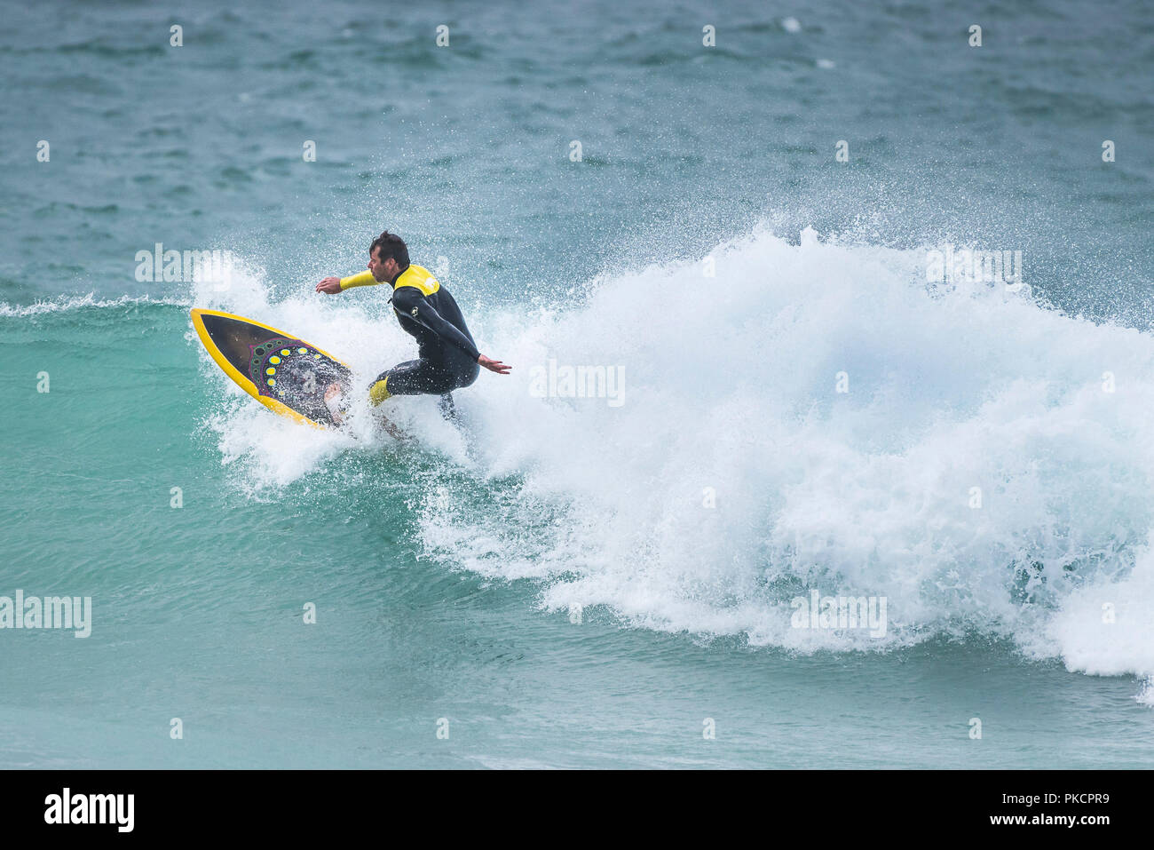 Ein Surfer auf einer Welle an Fistral in Newquay Cornwall. Stockfoto