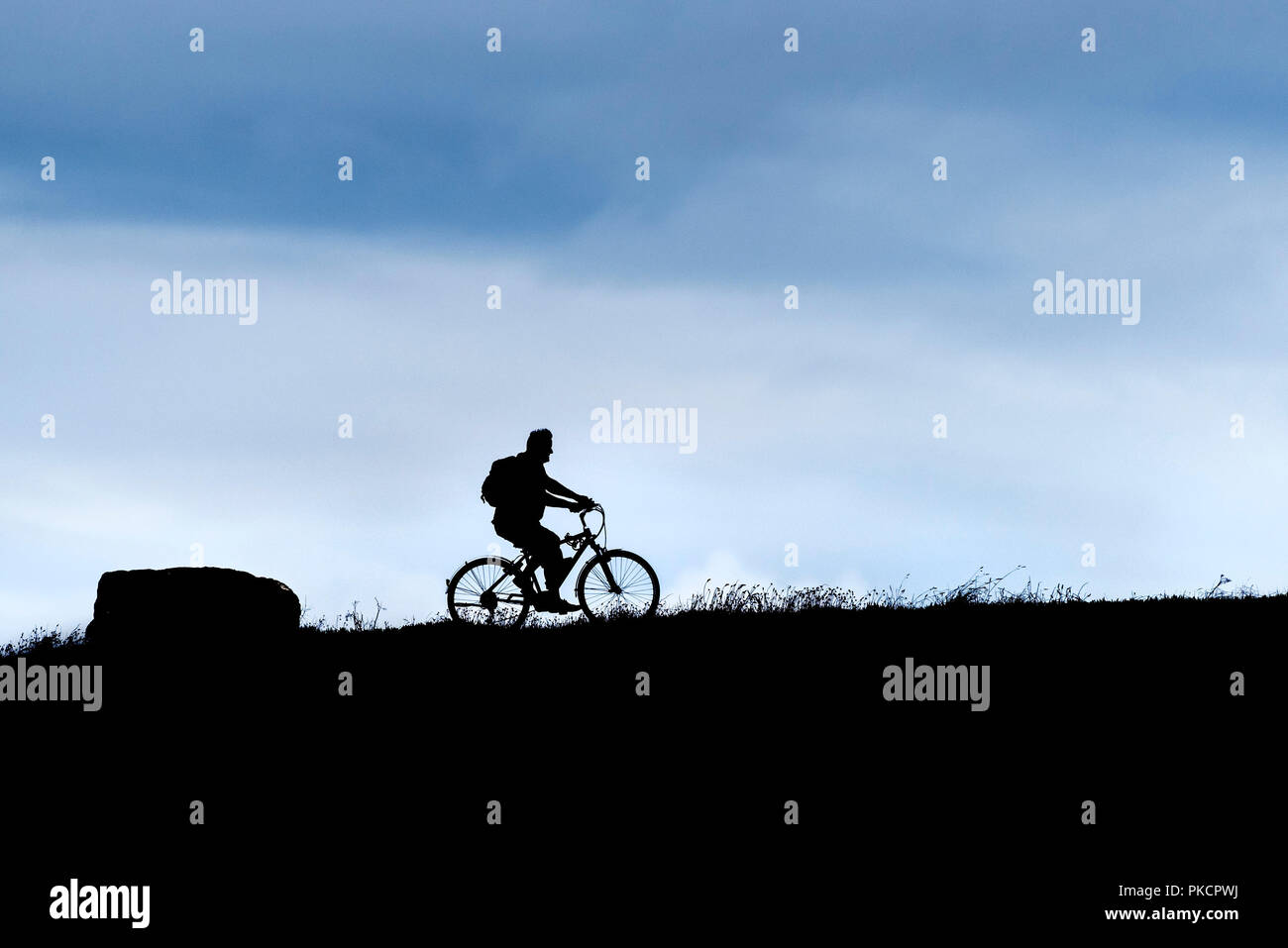 Die Silhouette eines Mannes auf einem Fahrrad. Stockfoto