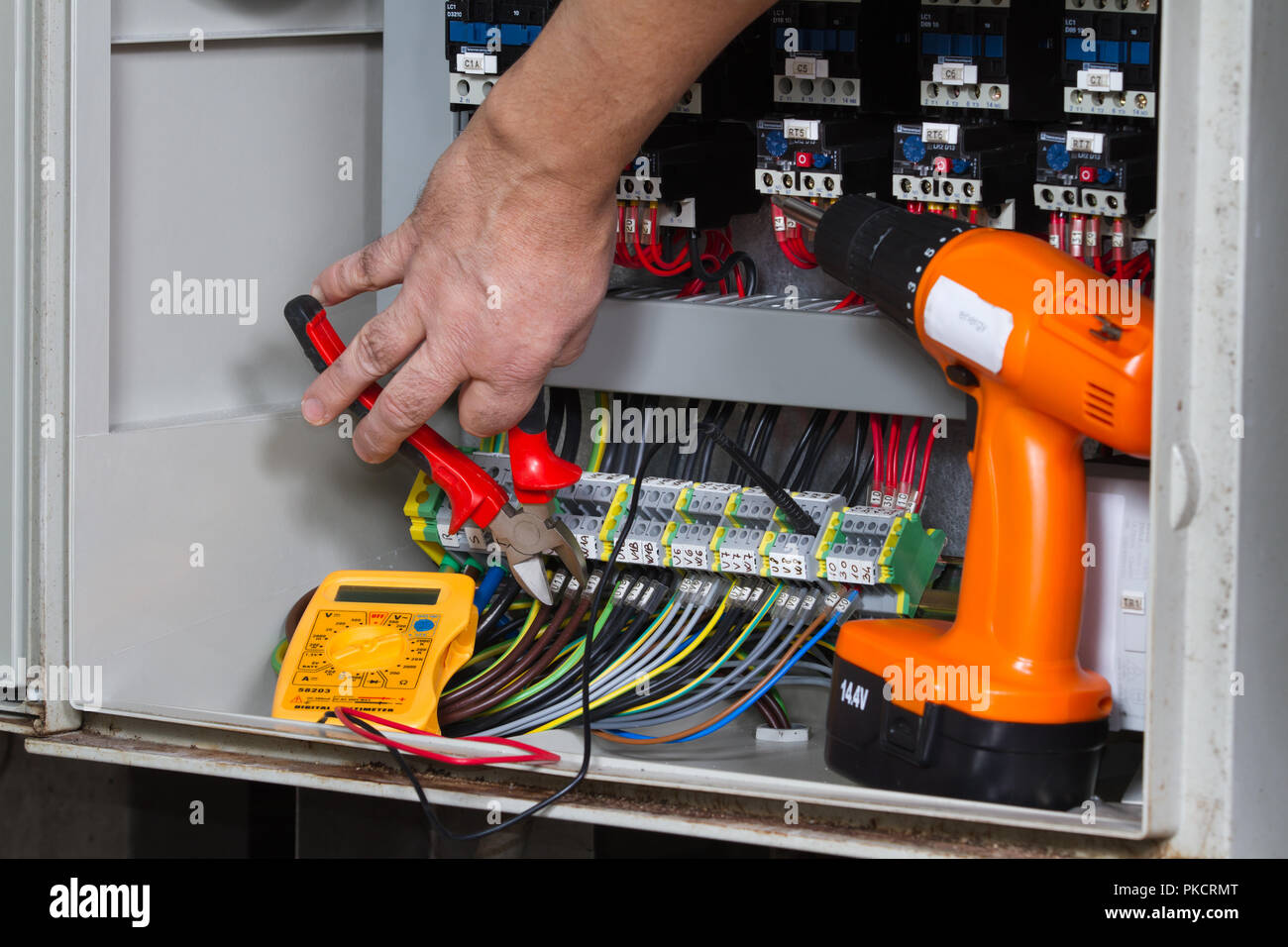 Elektriker bei der Arbeit mit einem elektrischen Bedienfeld Stockfoto